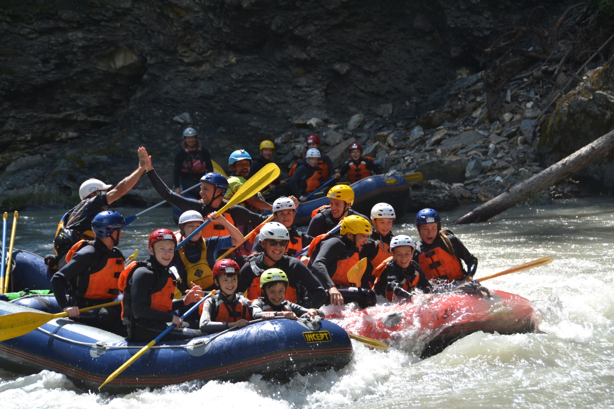 Schülergruppe auf mehreren Rafting-Booten auf dem Inn im Engadin